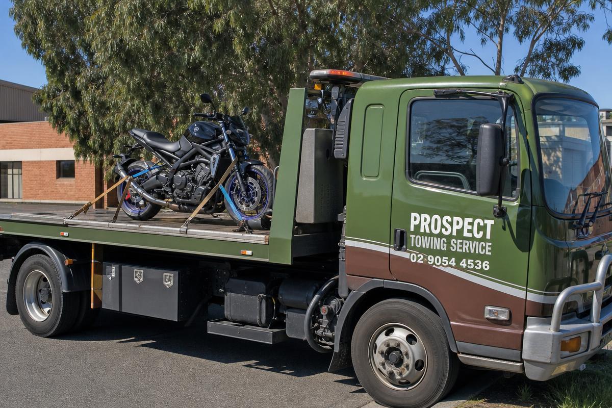 Motorbike strapped to a Prospect Tow Service flatbed tow truck